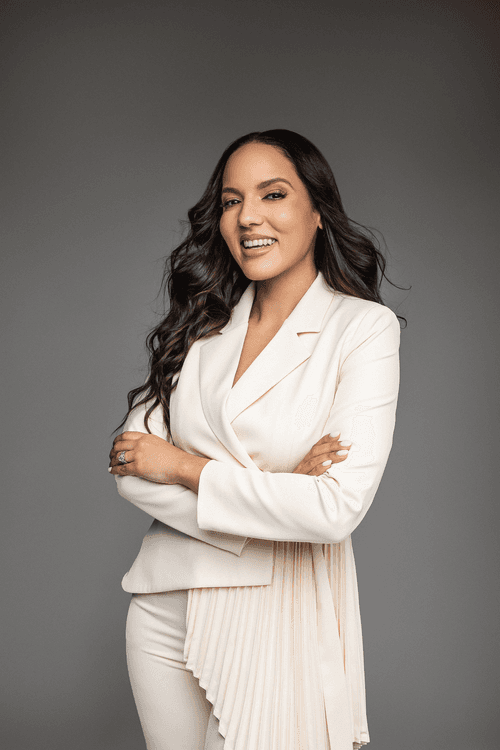 Amelia Garcia-Baumgardner, Licensed Professional Counselor, standing with arms crossed and a warm smile